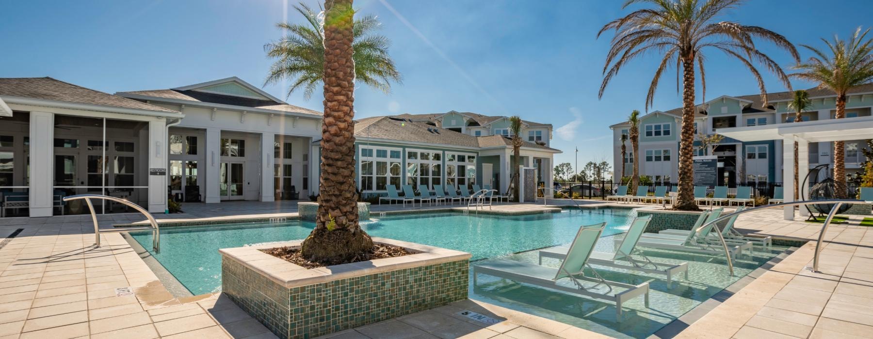 a pool with palm trees and a building in the background