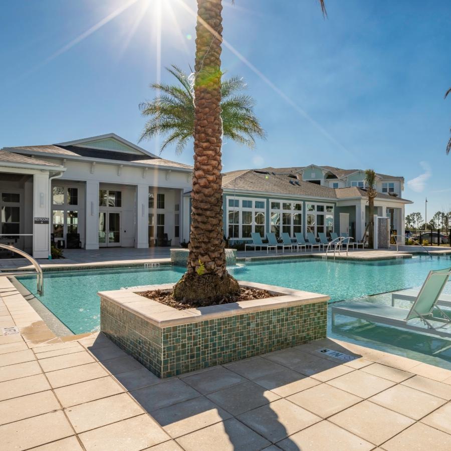 a pool with palm trees and a building in the background