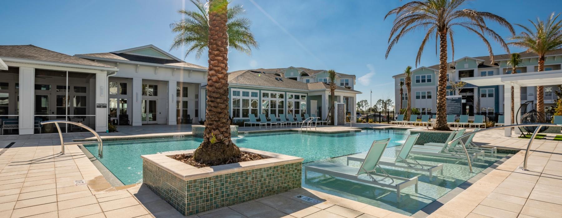 a pool with palm trees and a building in the background